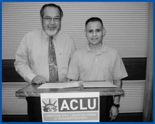 Montes v. Yakima and the fight for fairer elections in Washington Blog_display A black and white photo of two men standing behind a podium with an ACLU-WA sign on it