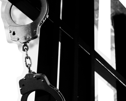 HomeSafe_parole_display a black and white image of handcuffs handing from metal bars.
