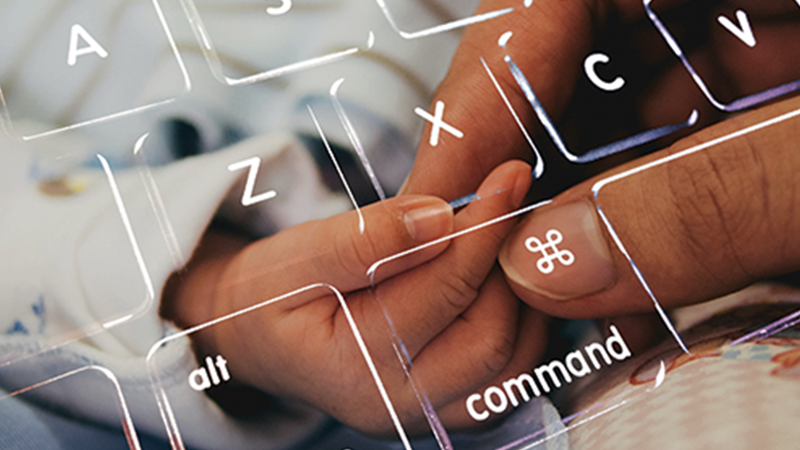 An image of an adult holding a baby's hand and a computer keyboard