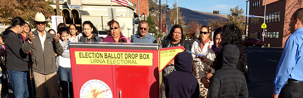 Photo of Latino voters standing around a ballot box in Yakima