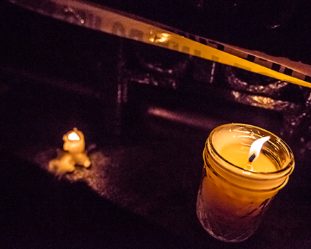 Photo of police tape and a candle at a protest of the murder of Philando Castile linking to an article on building trust between people and police