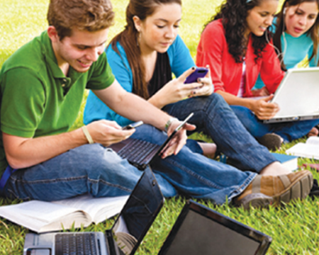 Photo of students using computers and mobile phones