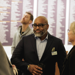 A group of three people smiling and talking