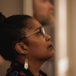 A person wearing glasses looking up with a contemplating and peaceful expression 