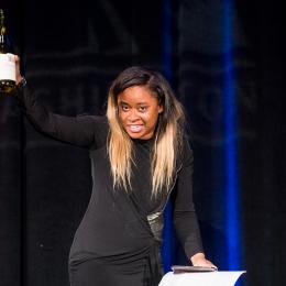 Photo of comedian Phoebe Johnson leading a toast at the 2016 ACLU of Washington Bill of Rights Dinner