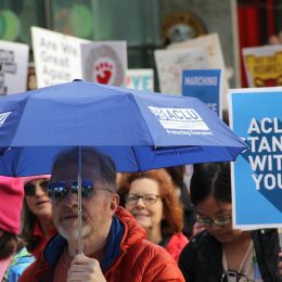 A marcher carrying an ACLU umbrella