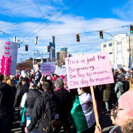 A photo of a marcher with a sign reading "This is only the beginning"