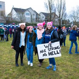 Marchers with a sign that reads "We are strong as hell"