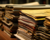 A photograph of multiple stacks of papers and file folders