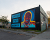 A colorful mural that says Justice for Manny with a portrait of him smiling